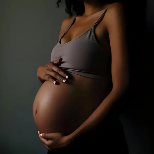 A girl expecting a baby holds her belly - pregnancy concept
